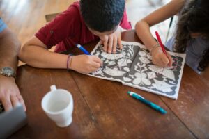 Children’s  working on coloring activity book together